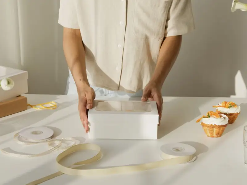 Dua tangan menutup kotak kue.